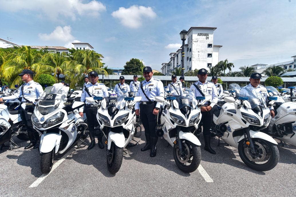Traffic police officers in Malaysia preparing to escort ASEAN Summit dignitaries with patrol cars and motorbikes.