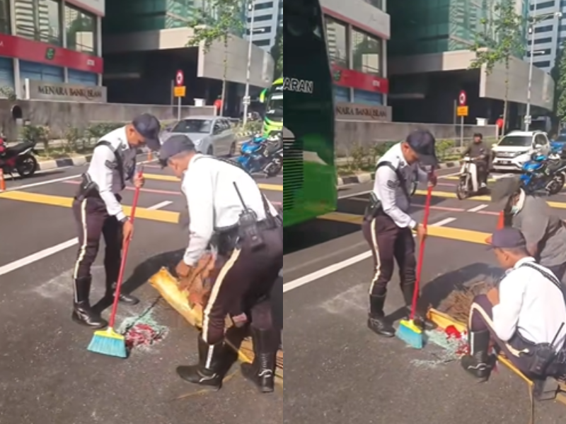 Traffic police officers cleaning up the debris from an accident.