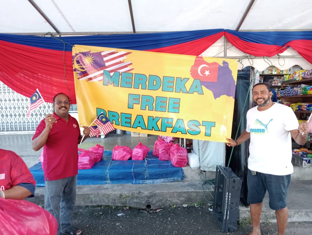 Devan and his staff distributing free breakfast meals and flags to the public in conjunction with National Day