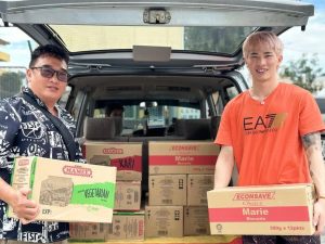 Chen Tang Jie and a PKSU representative delivering boxes of essential food supplies to support underprivileged communities