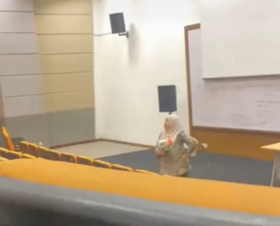 Madam Amie playfully pointing a water gun during lecture
