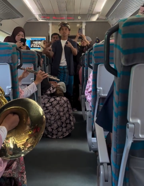 Student musicians from Sekolah Menengah Sains Machang fill the carriage with patriotic melodies under the direction of their conductor