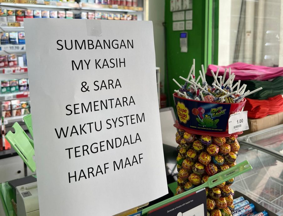 A notice at a supermarket informs customers that the MyKasih and SARA aid system is temporarily down