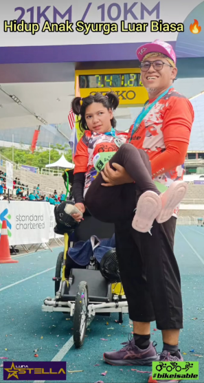 Screenshot from the video shows that a proud father lifting his daughter with celebral palsy after finishing their race together at KLSCM 2025
