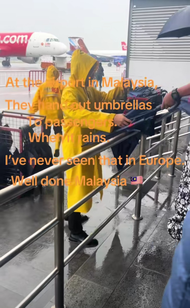 The airport personnel were distributing umbrellas one by one